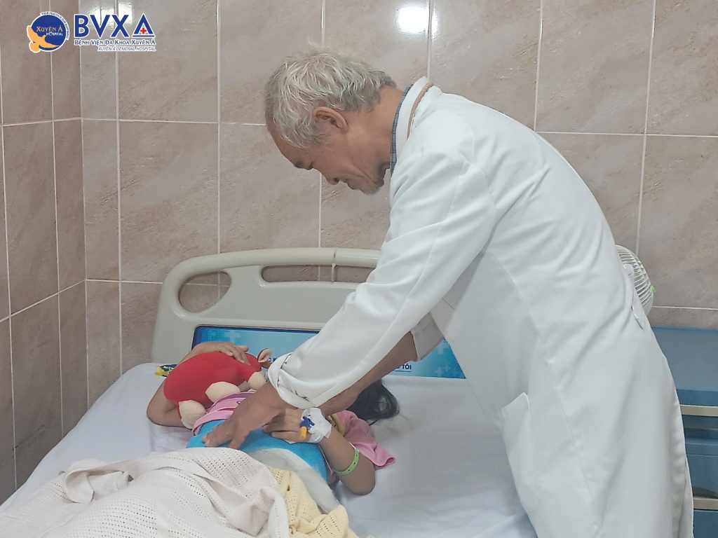 Hình ảnh BS. CKII. Phan Văn Tiếp thăm khám bệnh nhi bị trật khớp háng bẩm sinh