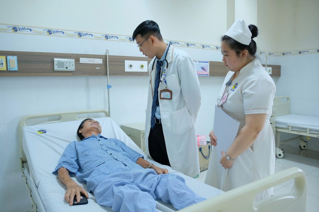 Hình ảnh bác sĩ thăm khám bệnh nhân điều trị sau khi ho ra máu