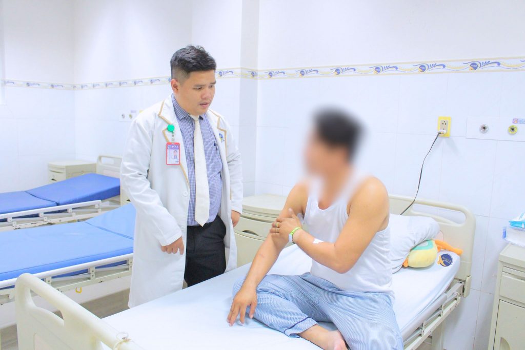 Hình ảnh bác sĩ và bệnh nhân bị thanh sắt đâm xuyên cánh tay sau phẫu thuật