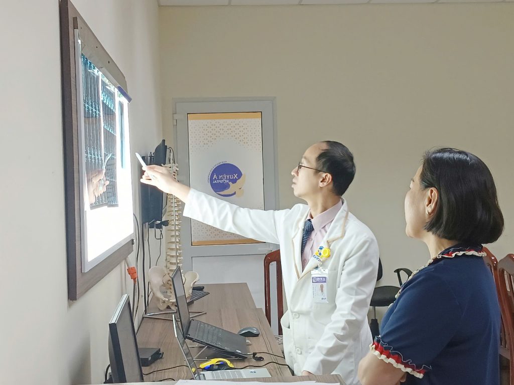 Bác sĩ tư vấn người nhà bệnh nhân A điều trị hẹp ống sống