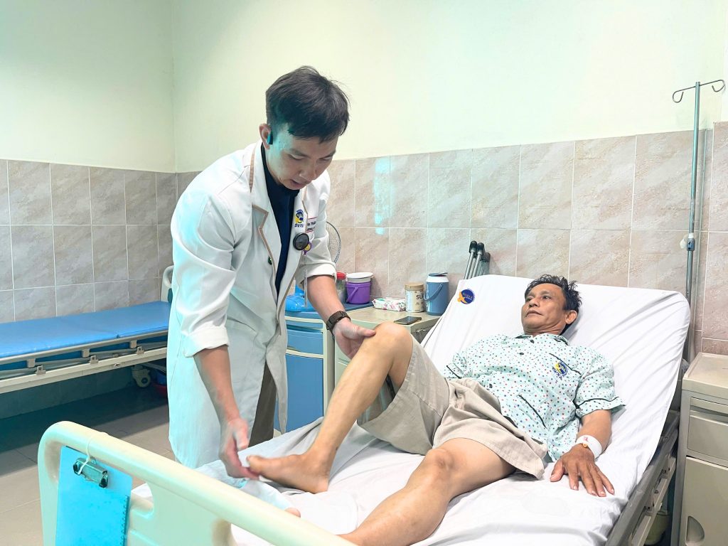 Hình ảnh bác sĩ thăm khám, kiểm tra bệnh nhân sau phẫu thuật gãy chỏm xương đùi