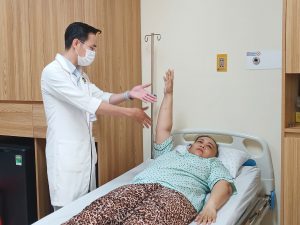 Hình ảnh bác sĩ kiểm trả chức năng sau mổ cho người bệnh bị vỡ túi phình động mạch não