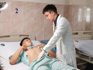 Hình ảnh bác sĩ thăm khám bệnh nhân bị tắc mạch cầm máu sau can thiệp