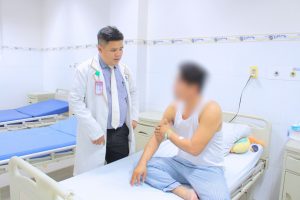 Hình ảnh bác sĩ và bệnh nhân bị thanh sắt đâm xuyên cánh tay sau phẫu thuật