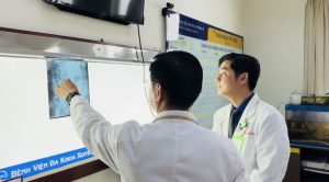 Hình ảnh bác sĩ xem kết quả cận lâm sàng của bệnh nhân vị sỏi thận